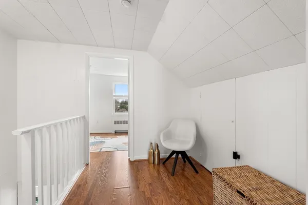 a view of a hallway with wooden floor and furniture