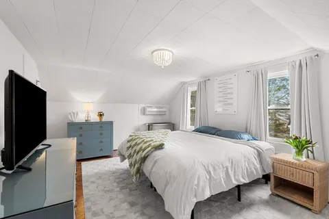 a spacious bedroom with a bed and a flat screen tv