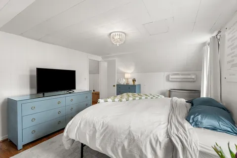 a bedroom with a bed and a flat screen tv