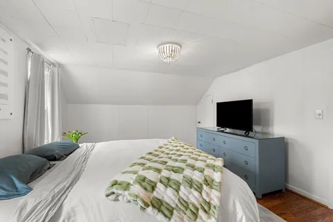 a bedroom with a bed and a flat screen tv
