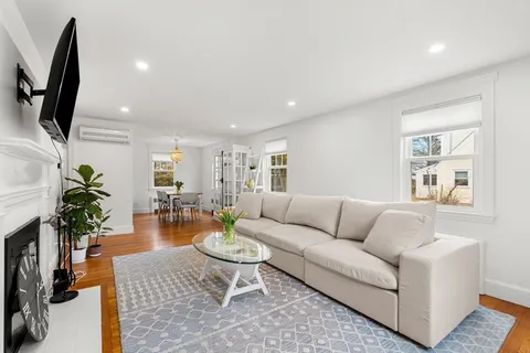 a living room with furniture wooden floor and a flat screen tv