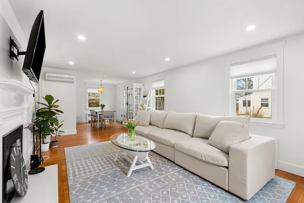 a living room with furniture wooden floor and a flat screen tv