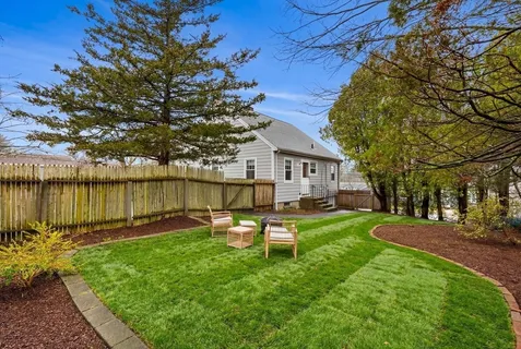 a backyard of a house with table and chairs