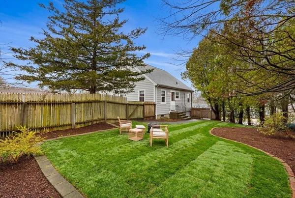 a backyard of a house with table and chairs