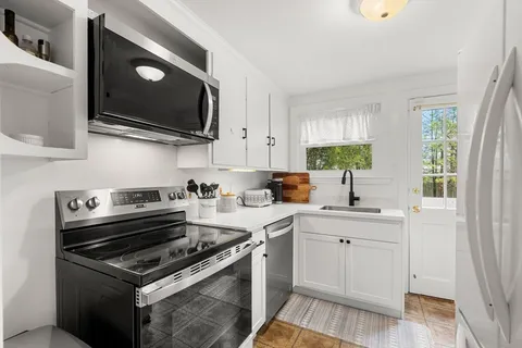 a kitchen with stainless steel appliances a sink a stove and microwave