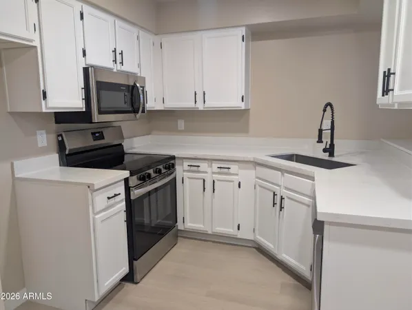 a kitchen with white cabinets and stainless steel appliances