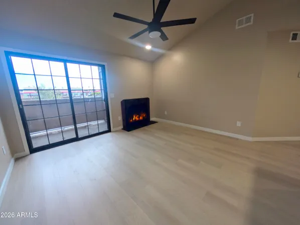 an empty room with fireplace and windows