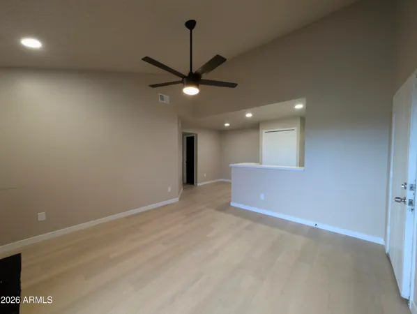 an empty room with a ceiling fan and a window