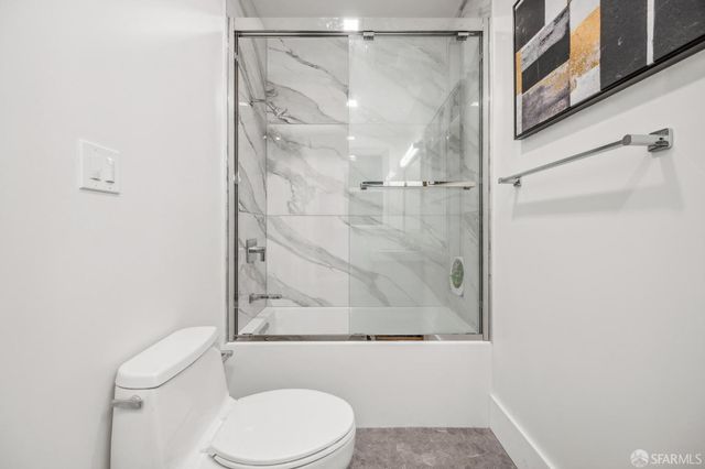 a white toilet sitting next to a bath tub