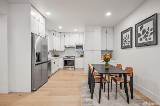 a kitchen with white cabinets and stainless steel appliances