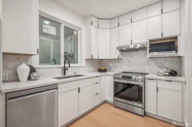a kitchen with stainless steel appliances granite countertop a stove sink and cabinets