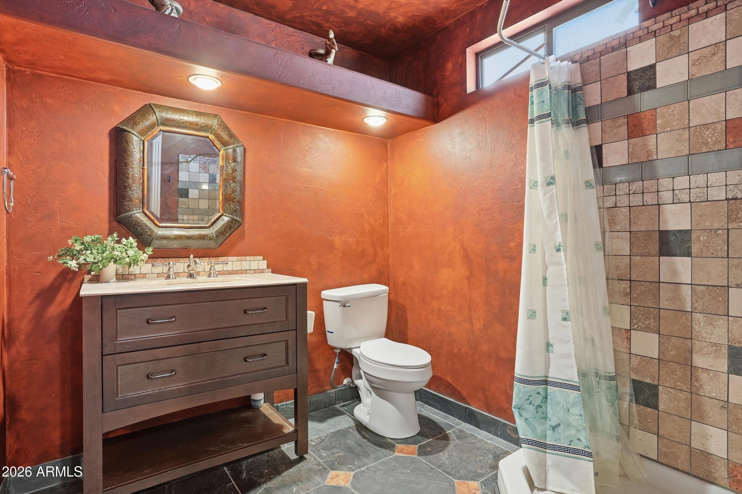 6334 East Albany Street Mesa, AZ 85205 - Photo 55 of 72 a bathroom with a toilet a sink and mirror