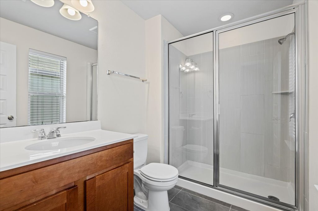 1502 Airedale Road, Unit 2502 Austin, TX 78748 - Photo 20 of 28 A well-lit primary bathroom featuring a large vanity and a glass-enclosed shower.