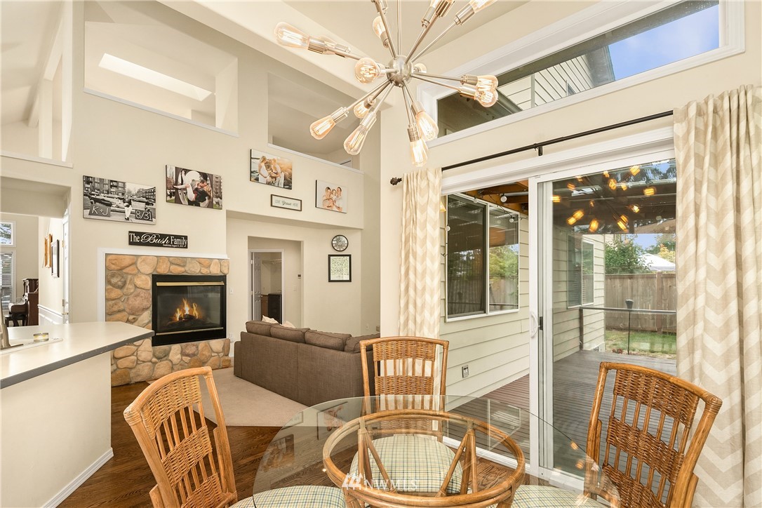 909 Graham Avenue Northeast Renton, WA 98059 - Photo 13 of 32 a living room with furniture a fireplace and a chandelier