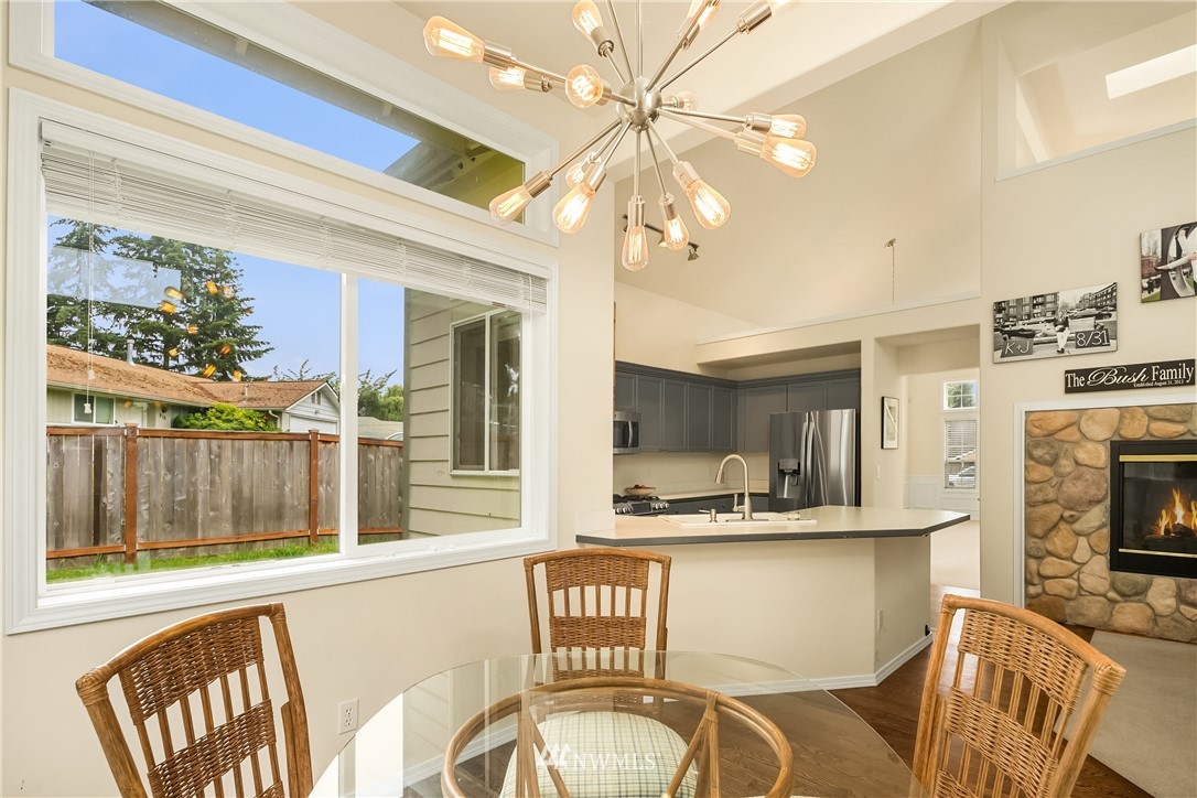 909 Graham Avenue Northeast Renton, WA 98059 - Photo 14 of 32 a kitchen with a table chairs refrigerator and a fireplace