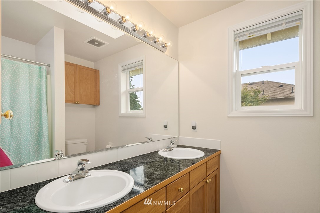 909 Graham Avenue Northeast Renton, WA 98059 - Photo 25 of 32 a bathroom with a granite countertop sink and a mirror