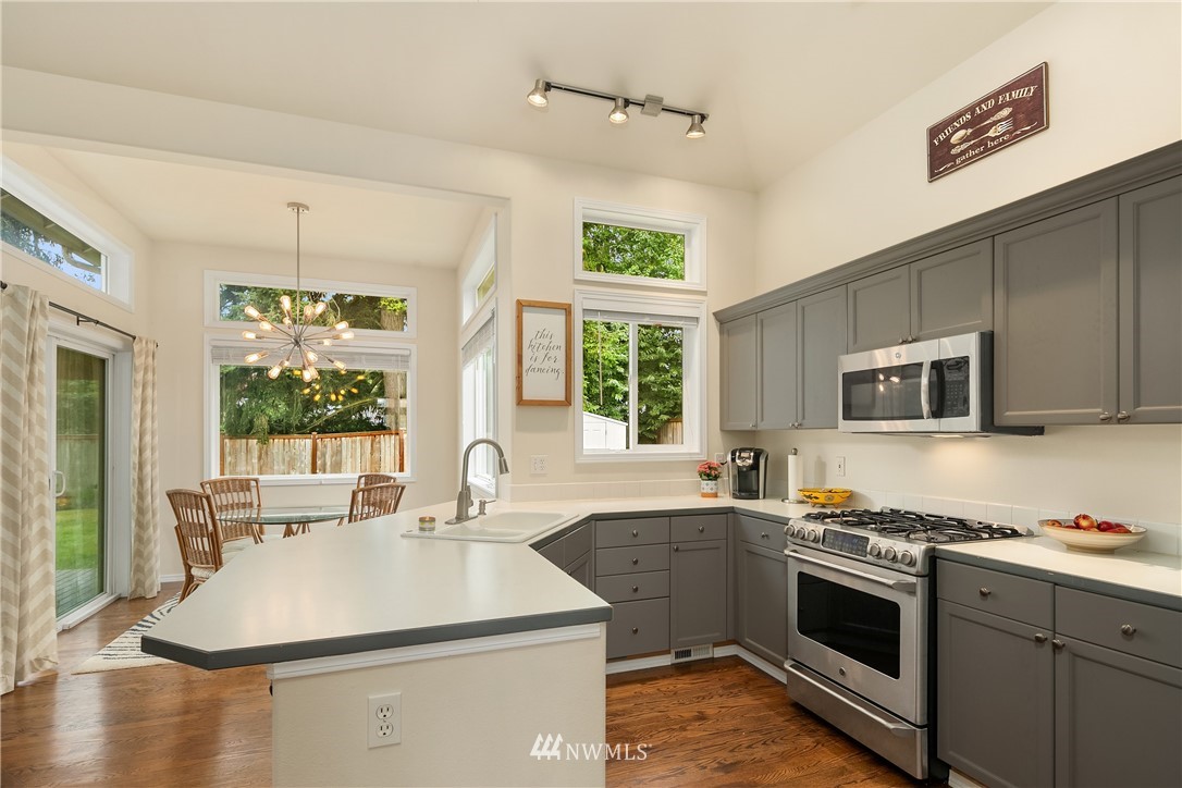 909 Graham Avenue Northeast Renton, WA 98059 - Photo 7 of 32 a kitchen with a sink stove and microwave