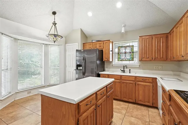 a kitchen with a sink a center island cabinets and appliances