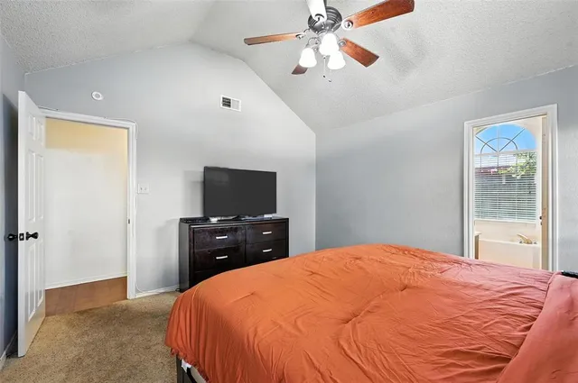 a bedroom with a bed and a flat tv screen on dresser