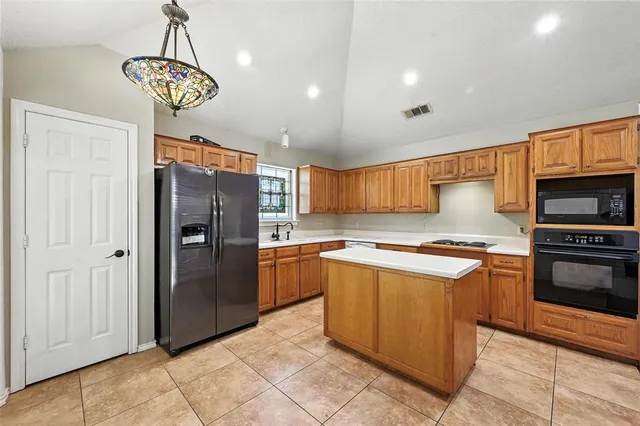 a kitchen with stainless steel appliances granite countertop a refrigerator and a stove top oven