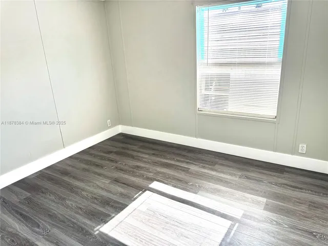 a view of a small space with wooden floor and a window