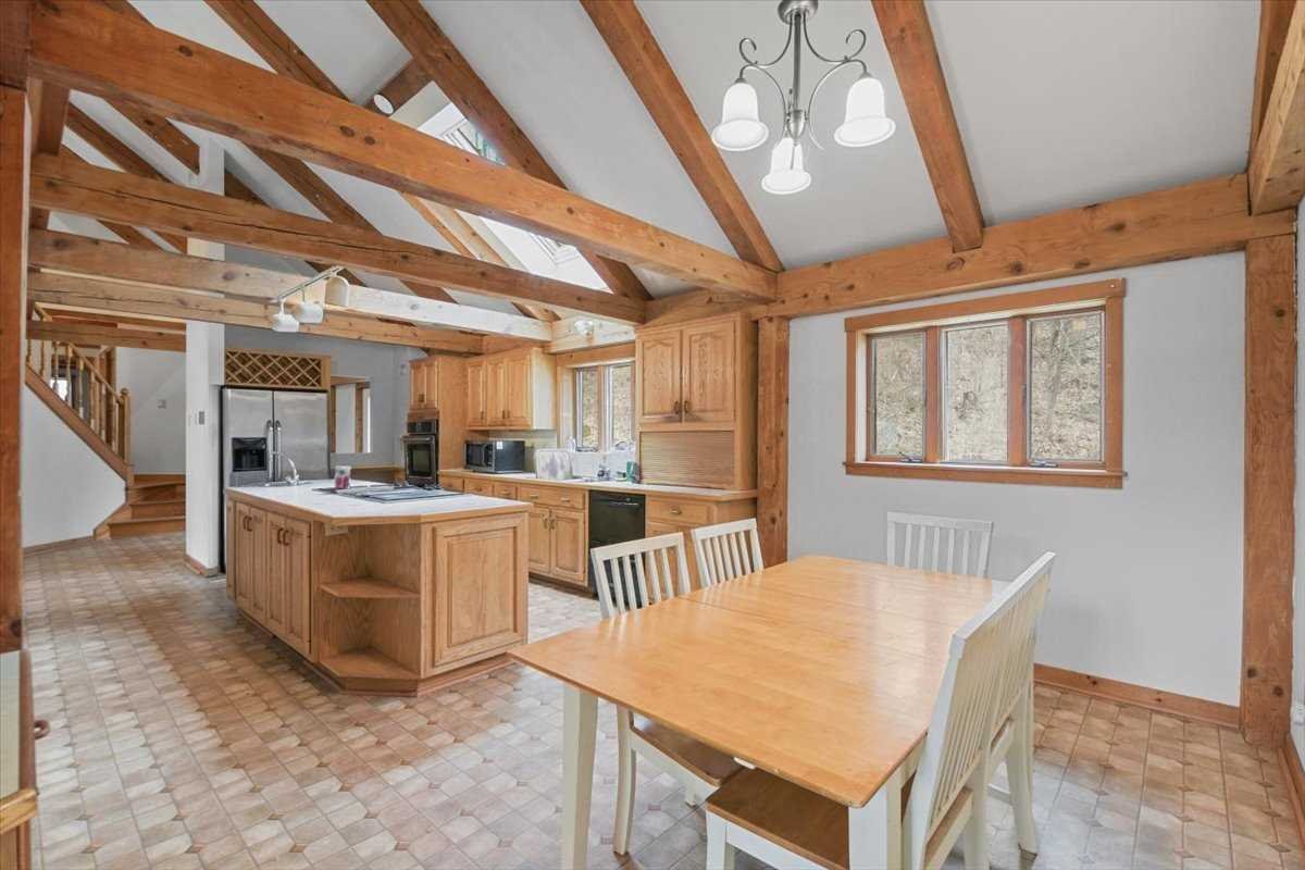 121 Cornwall Hill Road Patterson, NY 12563 - Photo 13 of 37 a kitchen with a stove a refrigerator a sink dishwasher with a dining table and chairs with wooden floor