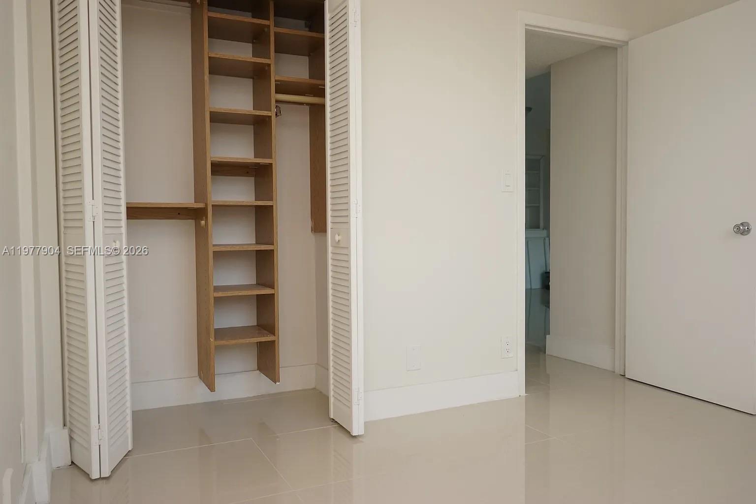 546 Southwest 1st Street, Unit 404 Miami, FL 33130 - Photo 5 of 9 a view of walk in closet with empty racks