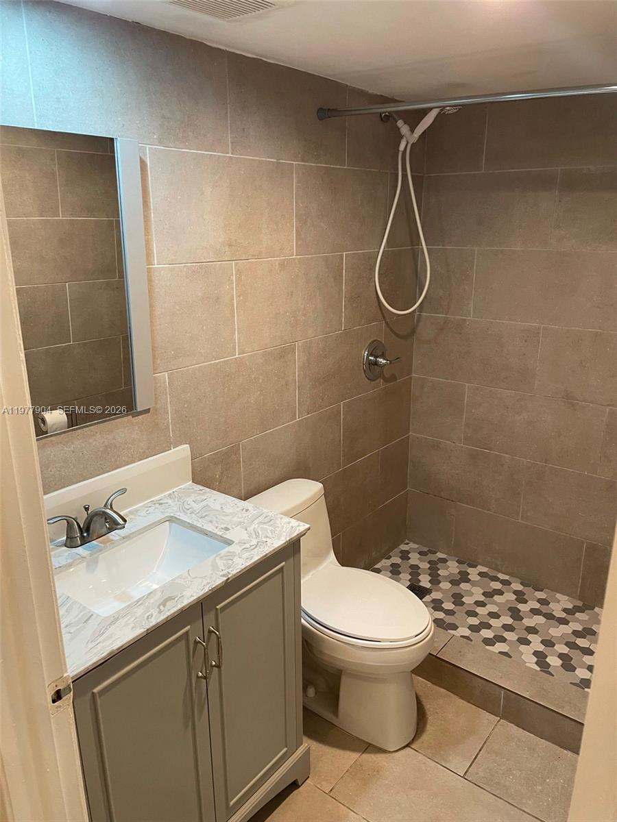 546 Southwest 1st Street, Unit 404 Miami, FL 33130 - Photo 6 of 9 a bathroom with a sink a toilet and shower