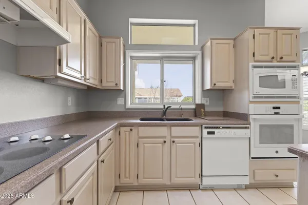 a kitchen with cabinets appliances a sink and a window