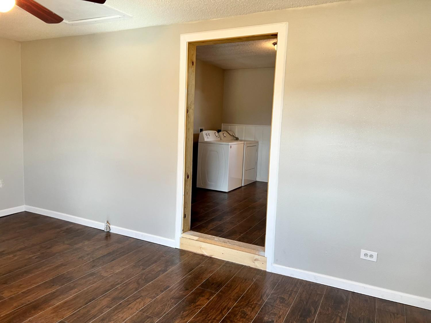 212 12th Street Ralls, TX 79357 - Photo 13 of 24 a view of a hallway with wooden floor and a bathroom