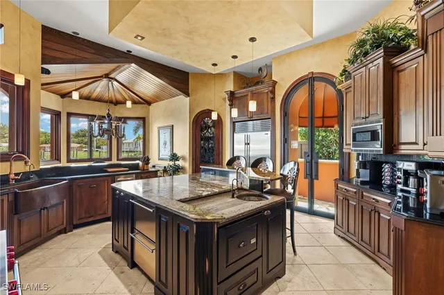 a kitchen with granite countertop a sink and a refrigerator