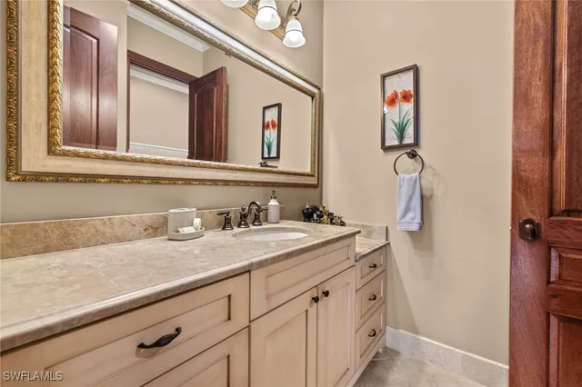 a bathroom with a granite countertop sink and a mirror