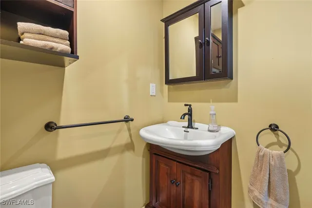 a bathroom with a sink a toilet and mirror