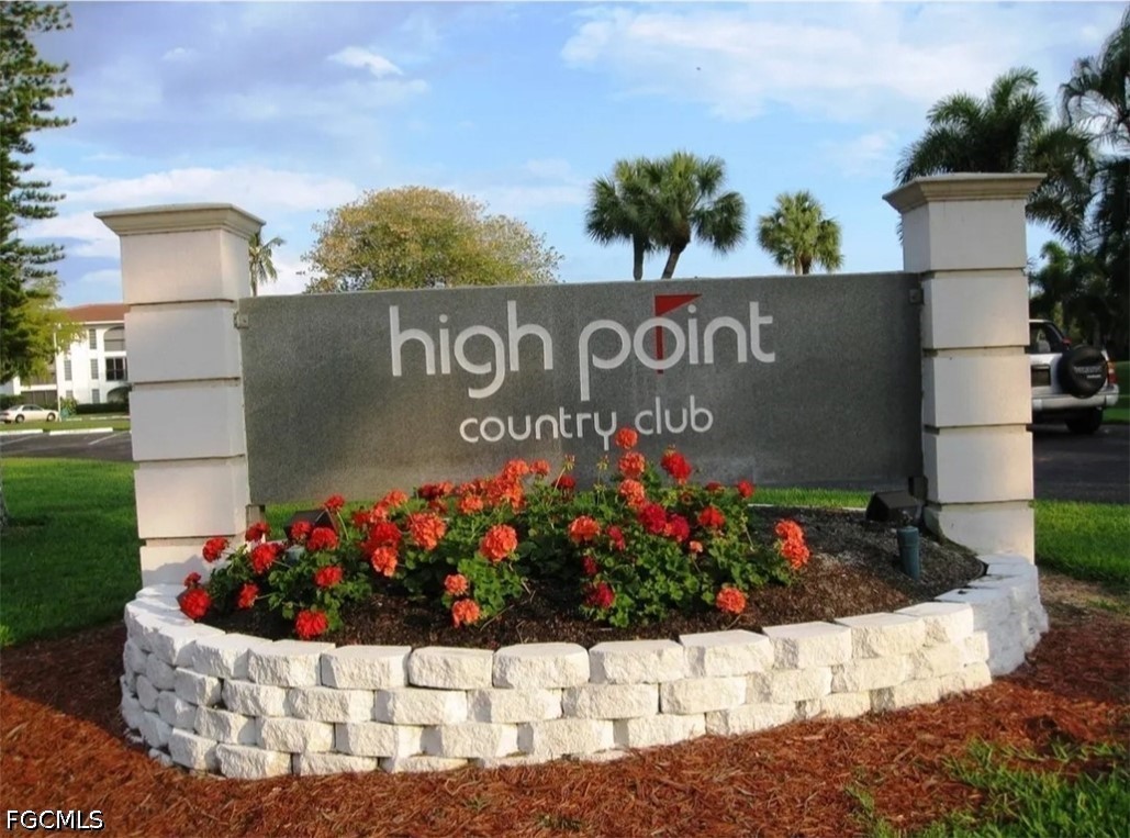 9 High Point Circle North, Unit 101 Naples, FL 34103 - Photo 39 of 49 a sign that is in front of flowers