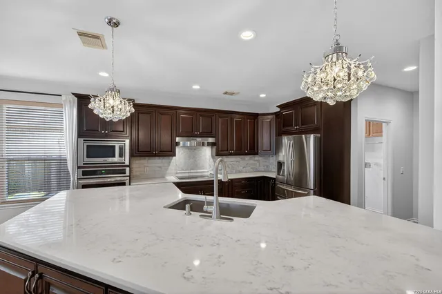 a kitchen with stainless steel appliances granite countertop a sink counter space and cabinets