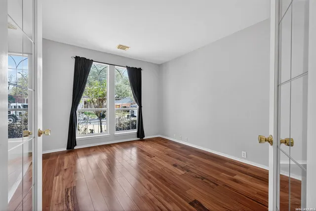 a view of an empty room with glass door and a window