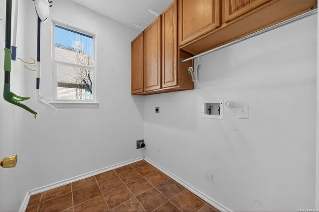a view of a house with a large tree and wooden fence