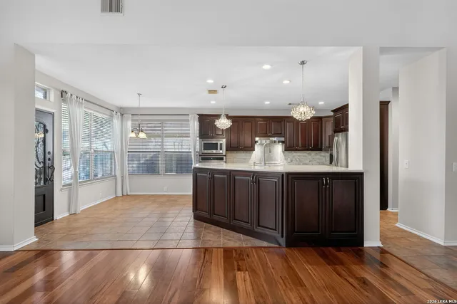 a kitchen with stainless steel appliances granite countertop a sink refrigerator and microwave