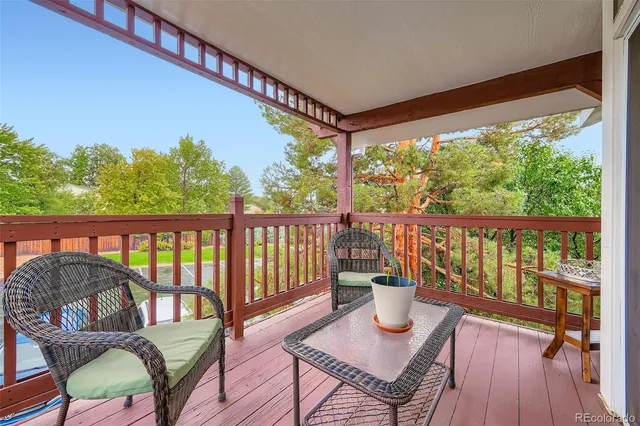 a view of a balcony with wooden floor and outdoor seating