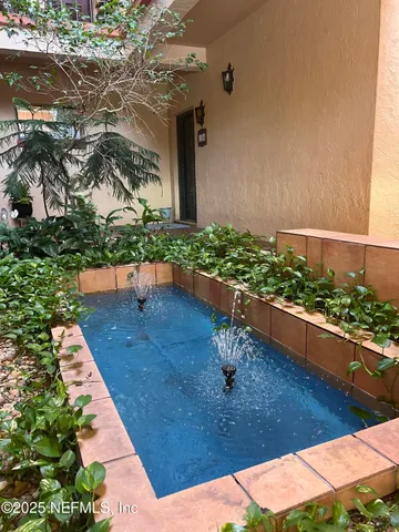 a view of a room with wooden floor and a chandelier