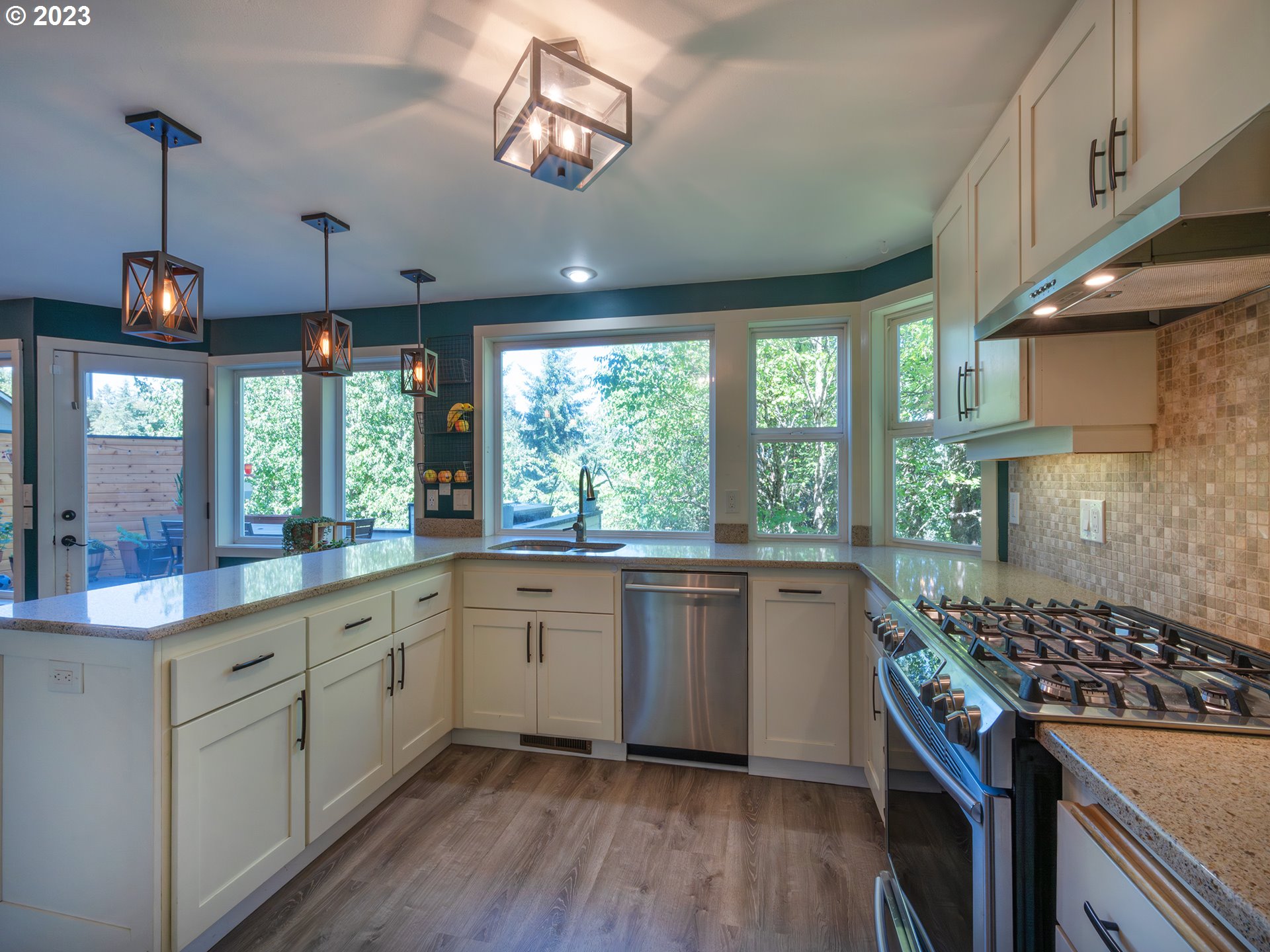 3875 Ashford Drive Eugene, OR 97405 - Photo 11 of 44 a kitchen with stainless steel appliances granite countertop a stove a sink dishwasher and white cabinets with wooden floor