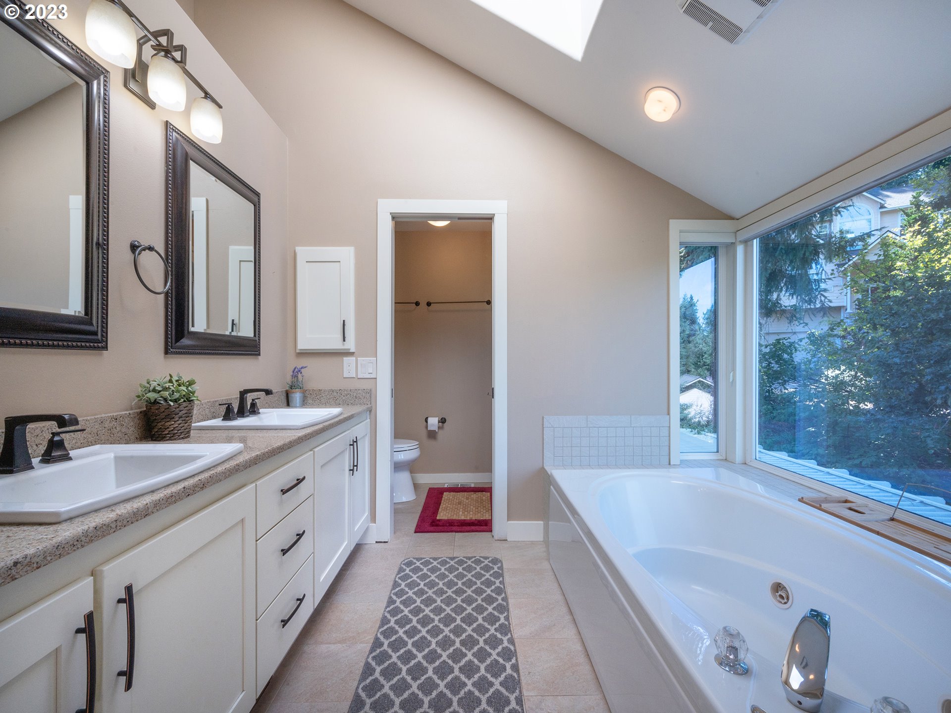 3875 Ashford Drive Eugene, OR 97405 - Photo 26 of 44 a spacious bathroom with a double vanity sink a large mirror and a bathtub