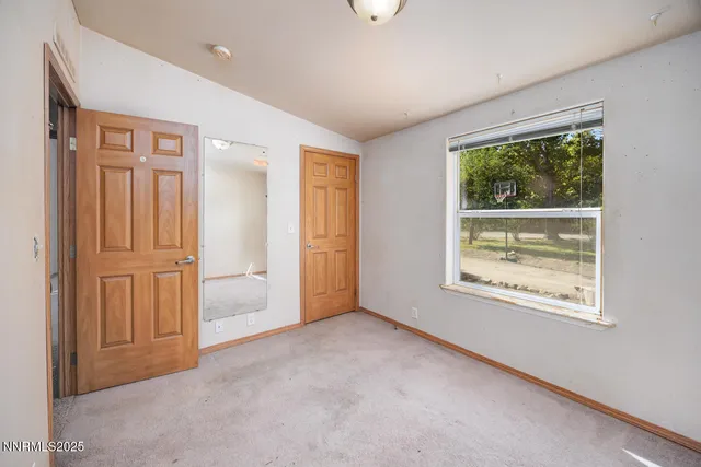 an empty room with windows and closet