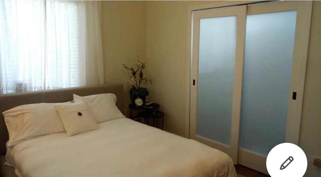 5718 Southwest 48th Street South Miami, FL 33155 - Photo 8 of 9 a bedroom with a bed and a window