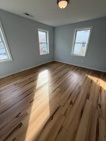 a bedroom with bed and wooden floor