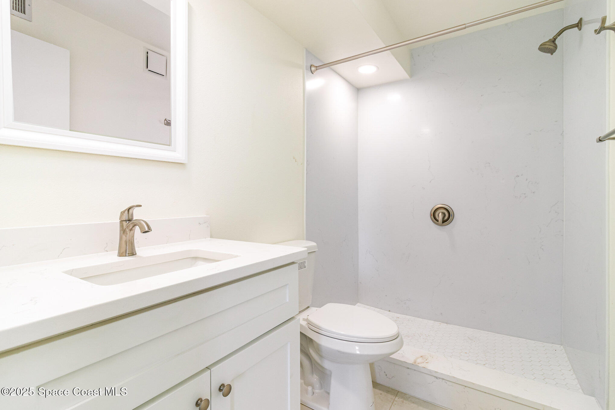 4105 Ocean Beach Boulevard, Unit 422 Cocoa Beach, FL 32931 - Photo 11 of 15 a bathroom with a sink a toilet and shower