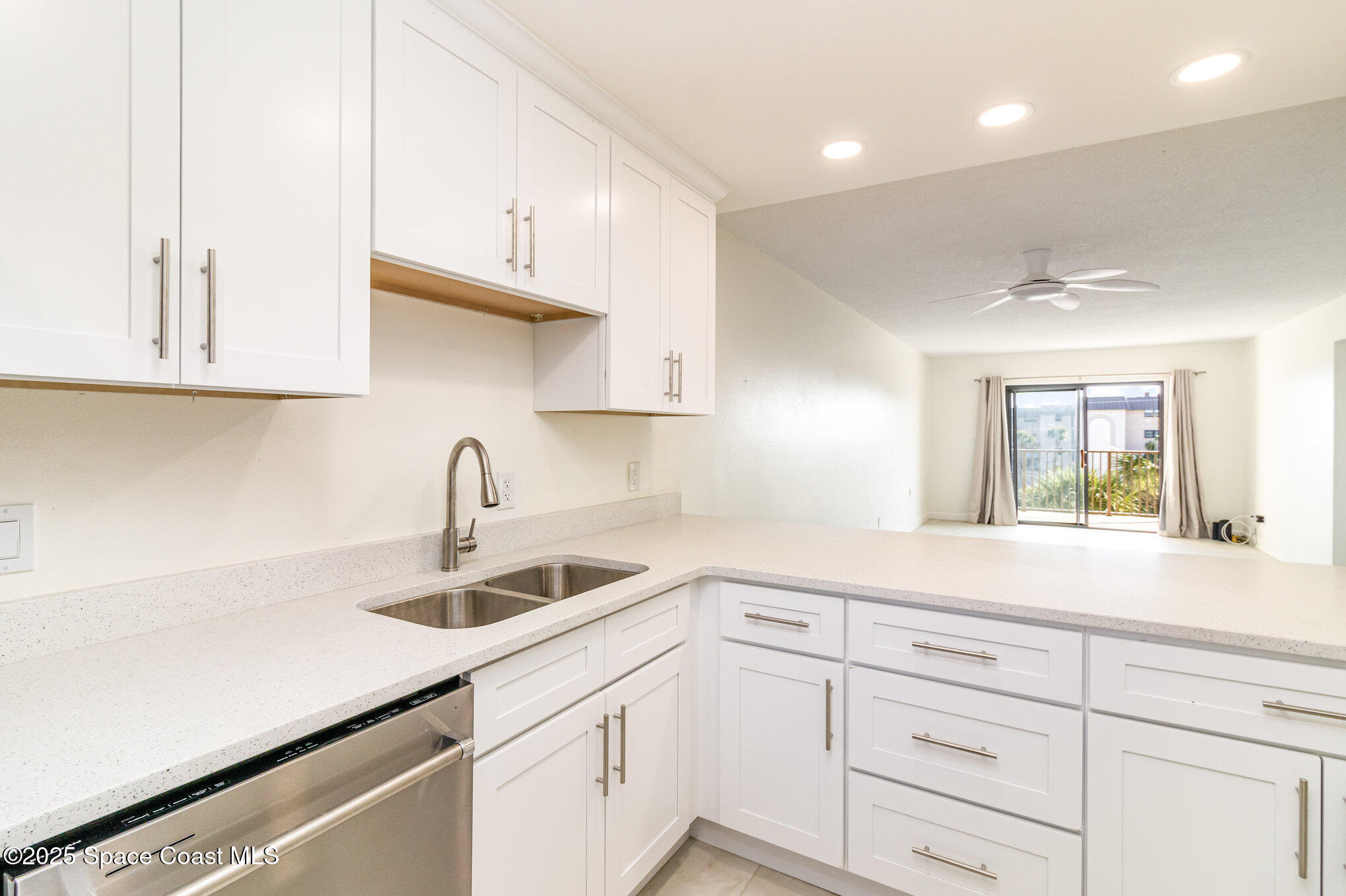 4105 Ocean Beach Boulevard, Unit 422 Cocoa Beach, FL 32931 - Photo 5 of 15 a kitchen with white cabinets and a sink