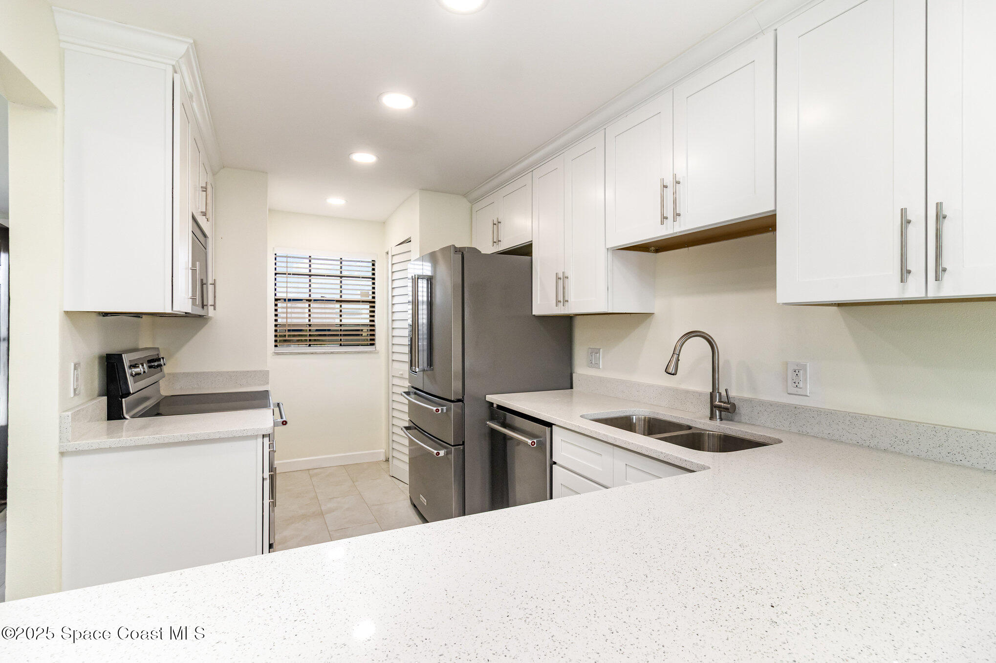 4105 Ocean Beach Boulevard, Unit 422 Cocoa Beach, FL 32931 - Photo 6 of 15 a kitchen with stainless steel appliances granite countertop a sink a stove a refrigerator and cabinets
