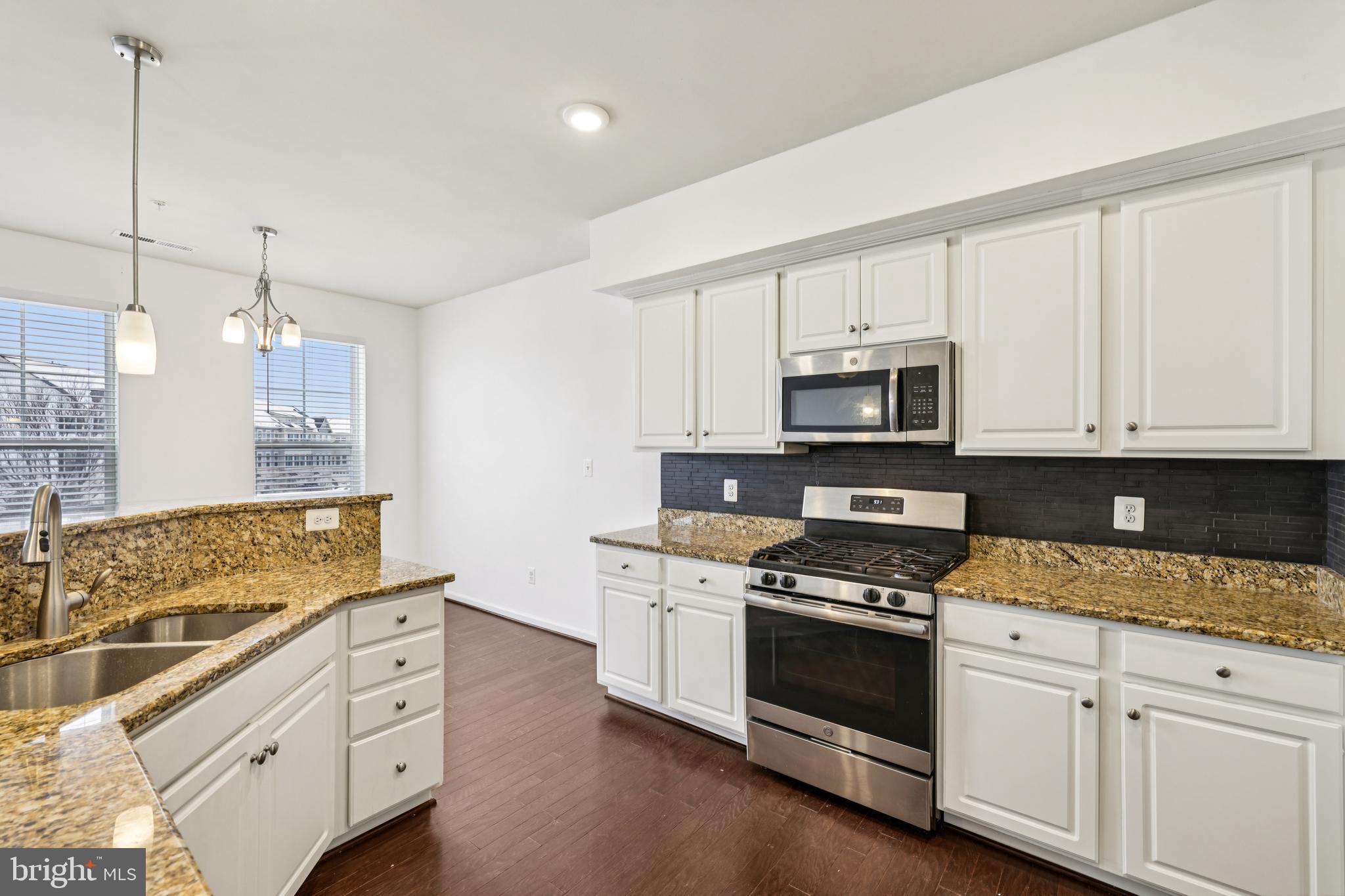 5841 Bella Marie Way Frederick, MD 21703 - Photo 11 of 45 a kitchen with granite countertop white cabinets white stainless steel appliances with a sink and dishwasher