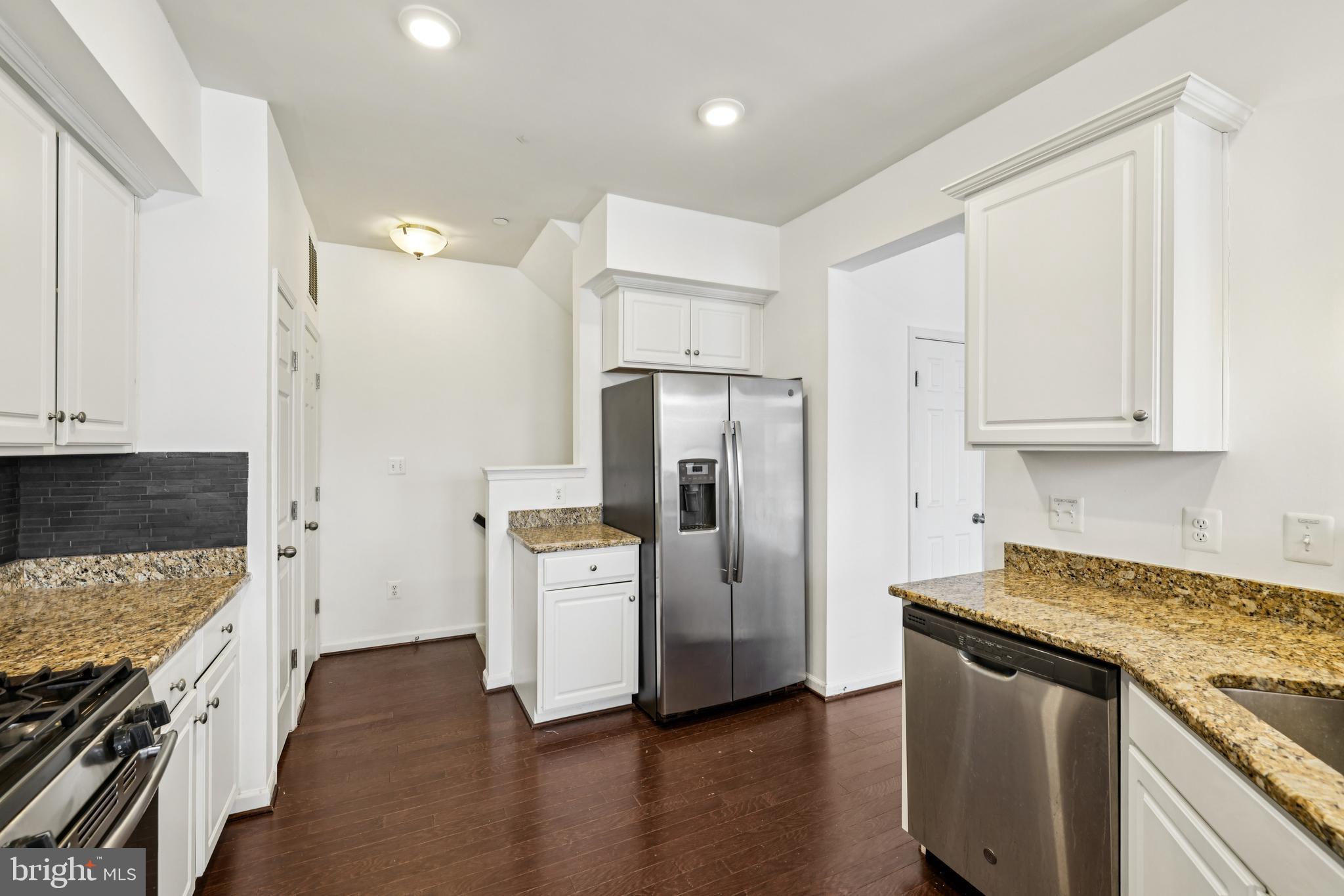 5841 Bella Marie Way Frederick, MD 21703 - Photo 13 of 45 a kitchen with stainless steel appliances granite countertop a refrigerator a stove and white cabinets with wooden floors